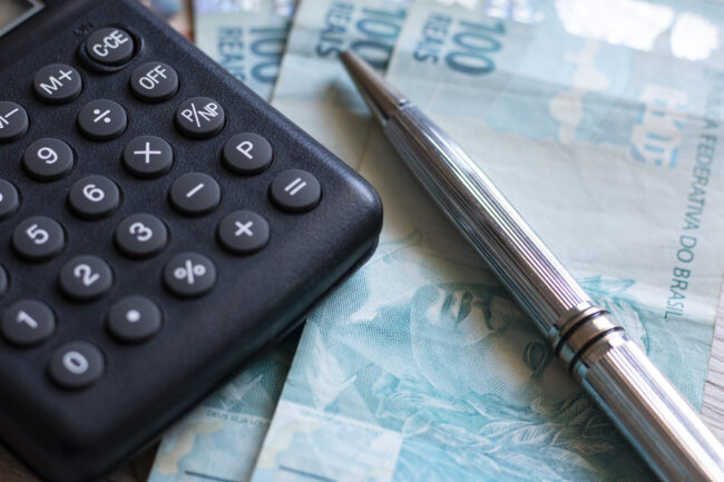 Finance Concept – Calculator, Brazilian Money and Pen